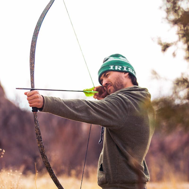 man in brown and black plaid long sleeve shirt holding bow